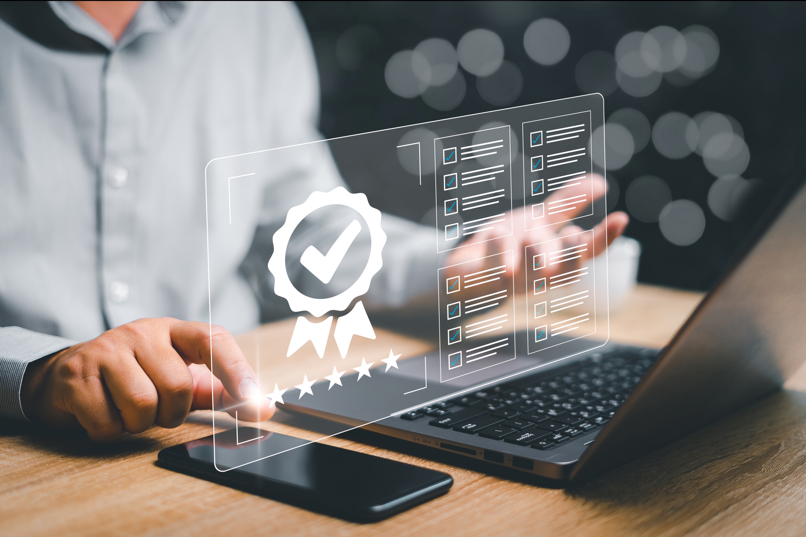 Close up of a person using a laptop and cell phone with a generated certification graphic overlay.
